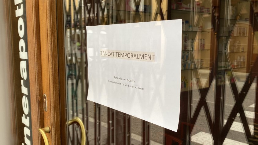 Imatge de la farmàcia de Castellfollit de la Roca, tancada i amb aquest cartell informatiu (Roger Isern)